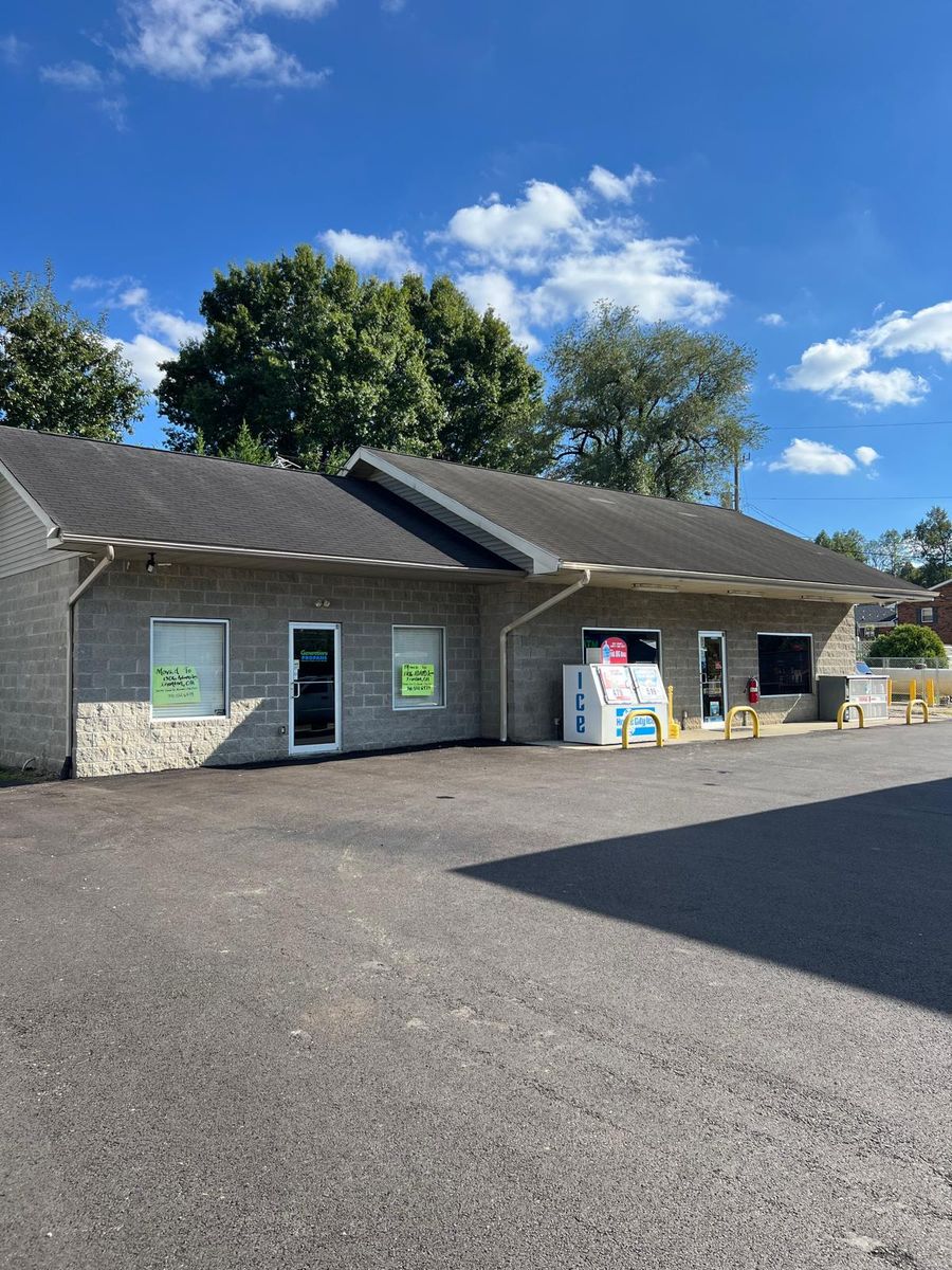 The Kash Stop store building and parking lot on a sunny day